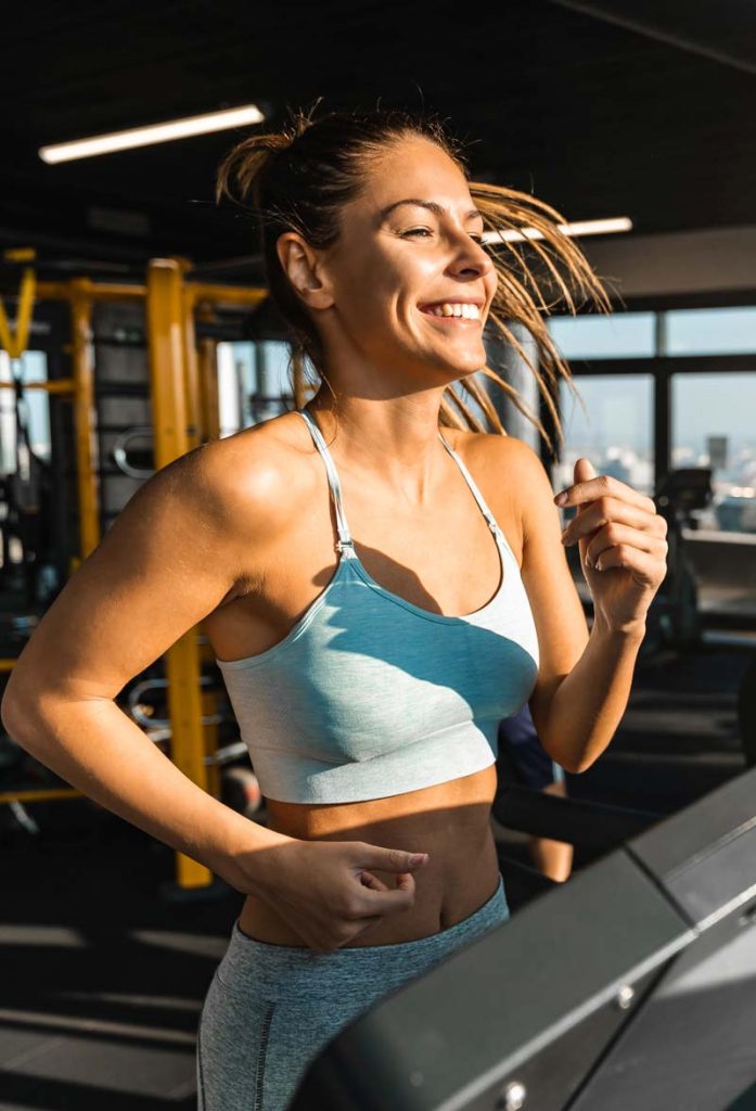 Smiling woman running on treadmill